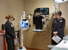 Dr. Daniel Cabrera (on screen) controls a telemedicine unit from a remote location during a tour of the remodeled emergency department at Mayo Clinic Health System in Lake City. At left is Heidi Harms, an emergency nurse practitioner. At right is Carolyn Ellingson, Mayo Clinic Health System’s operations manager in Lake City.